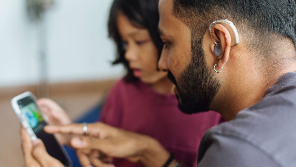 Modern hearing aids helping a father talk to his kid